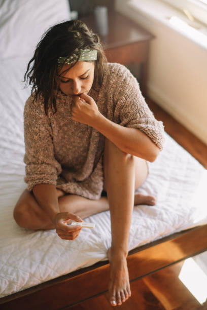 istock Worried young woman with holding pregnancy test 1225002919