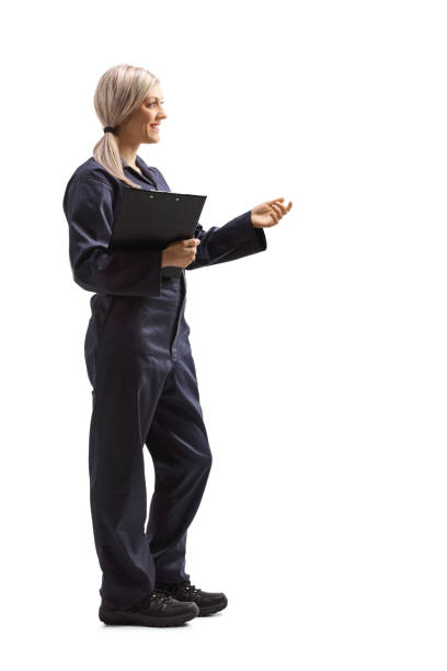 istock Female worker in an overall uniform holding a clipboard and gesturing with hand 1225010229