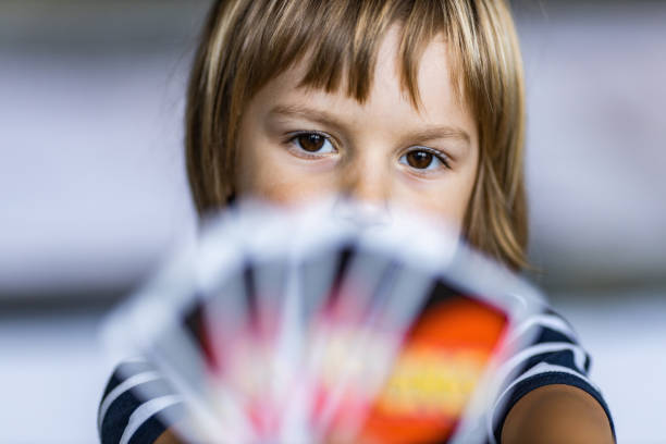 istock Cute little boy playing cards at home. 1225010529