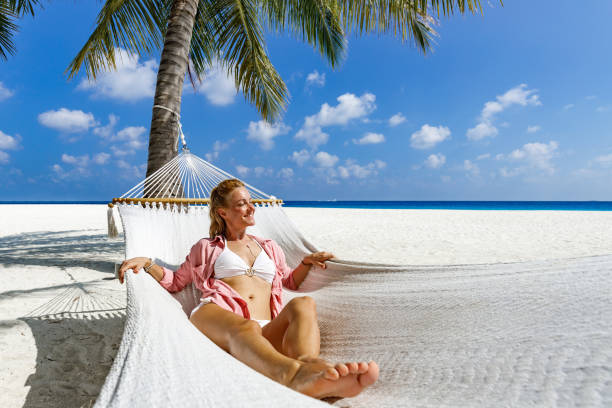 istock Happy woman relaxing in hammock on the beach. 1225010779