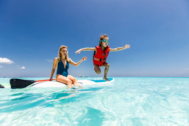istock Happy single mother and son having fun on paddle board at sea. 1225010810