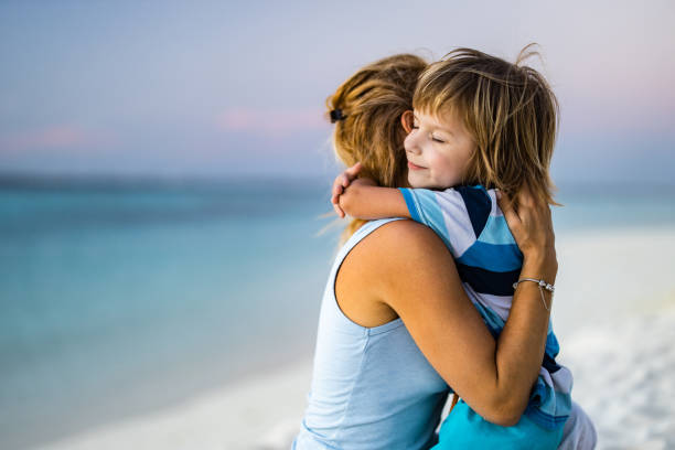 istock Loving single mother and son embracing on the beach. 1225011937