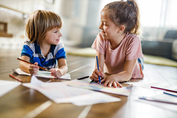 istock Happy little kids talking while drawing on floor at home. 1225014728