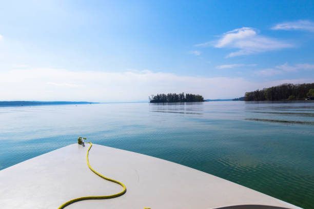 boat in the foreground on a calm lake, starnberg lake bavaria germany