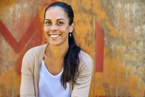 Portrait of a happy young aboriginal woman on an industrial background.