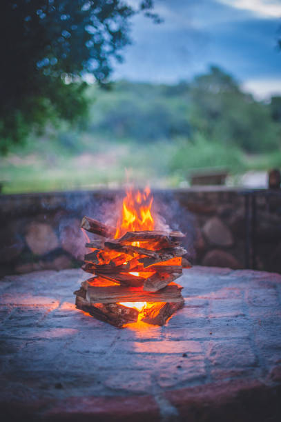 Campfire burning on fireplace in African bushveld at sunset.