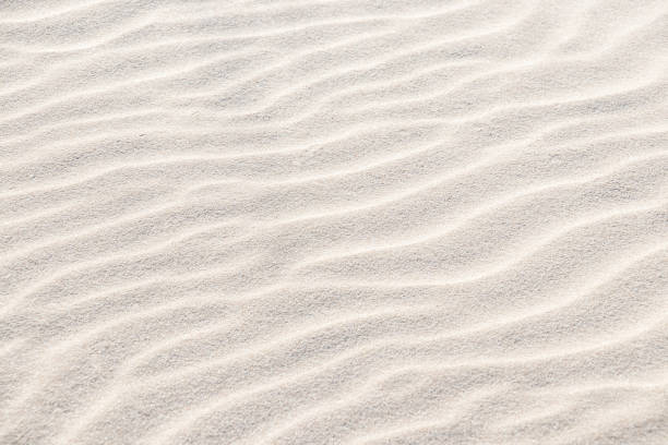 istock Beautiful light sand texture. Wave texture on the sand. Sandy beach for a background. Top view. 1225017304