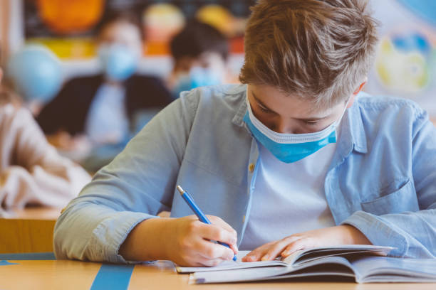 istock High school student at school, wearing N95 Face masks. 1225023160