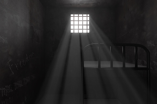 3d rendering of grunge prison cell with bunk bed and light ray of window
