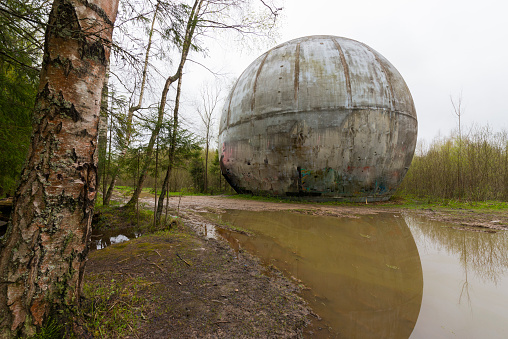 Abandoned construction in the form of a huge geodetic ball on the edge of a desert forest