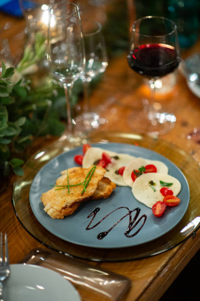 istock Caprese Salad Starter on a Plate with Red wine on a table ready to eat 1225026640