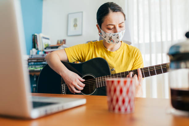 istock Woman Learning to Play Guitar at Home 1225026988