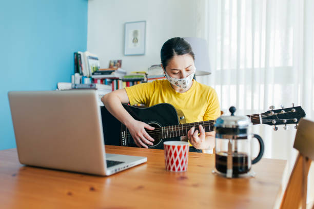 istock Woman Learning to Play Guitar at Home 1225026990