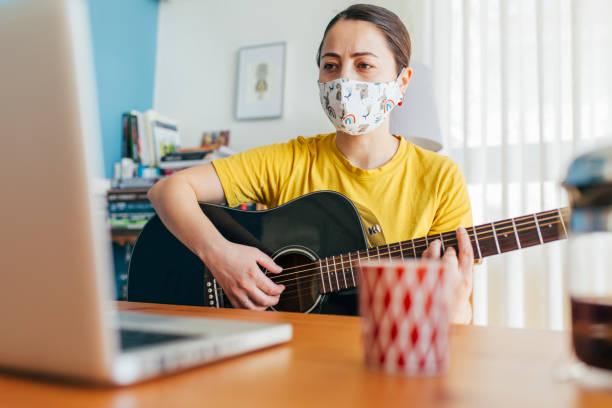 istock Woman Learning to Play Guitar at Home 1225026993