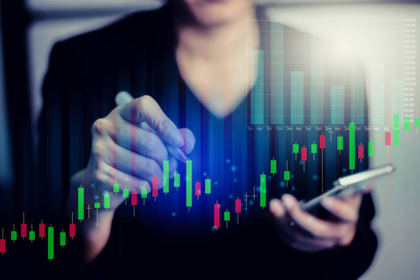 istock Businesswoman using writing and mobile phone on business financial data. Analyzing financial data and stock graph. Analysis of numerical data and stock market communication with businesses worldwide. 1225027011