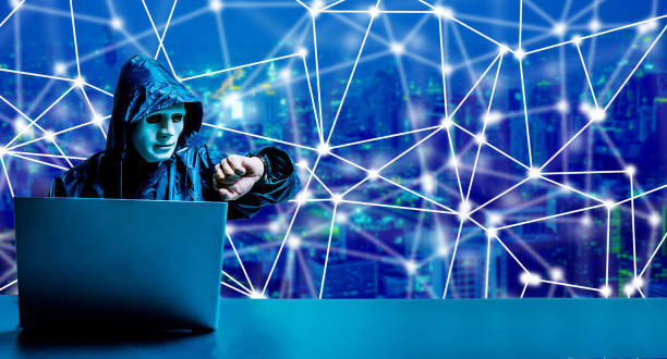 anonymer computer-hacker in weißer maske und hoodie. verschleiertes dunkles gesicht mit laptop-computer für cyber-angriff und überprüfung der zeit auf modernen stadthintergrund, datendieb, internet-angriff, darknet und cyber-sicherheitskonzept. - zeitdieb fotos stock-fotos und bilder