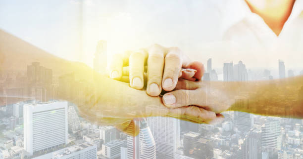 istock Double exposure Teamwork business join hand together concept, Image of shake hands and folding their hands on hands of success concept Symbol of cooperation in city background with copy space. 1225027178
