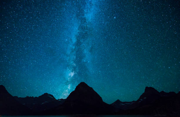 swiftcurrent lake  at night with star in many glacier area ,montana's glacier national park,montana,usa. - dusk blue montana landscape imagens e fotografias de stock