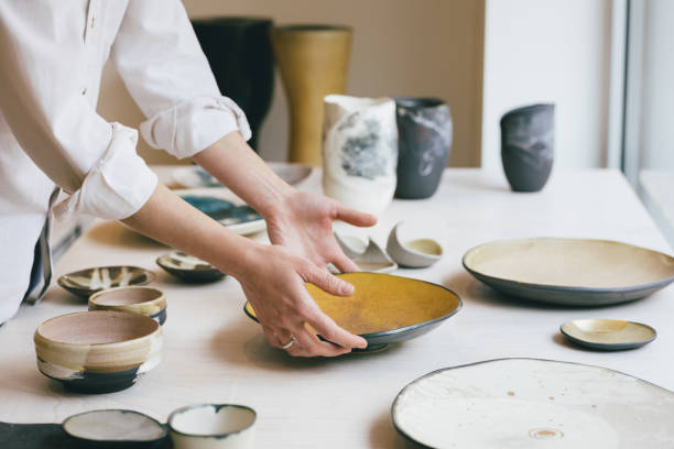 cearamic dishware w: gallery, handmade plate being put into a shop window - earthenware zdjęcia i obrazy z banku zdjęć