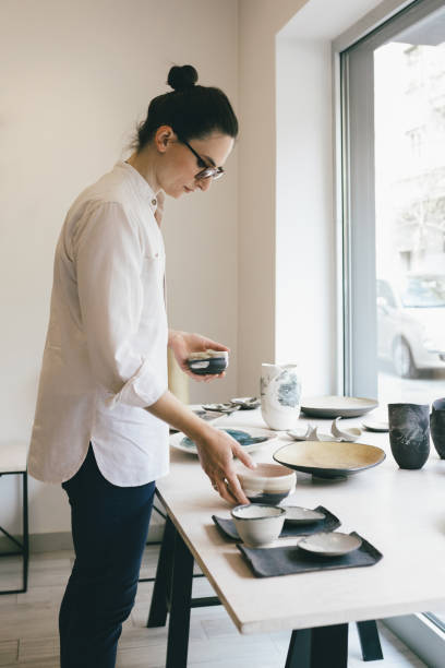 istock Woman Working at Gallery Arranging Pottery Pieces 1225029925