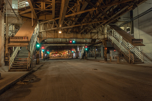 Chicago, Illinois. USA - May 1, 2020: Empty street in downtown Chicago at night with train overpass and stairs