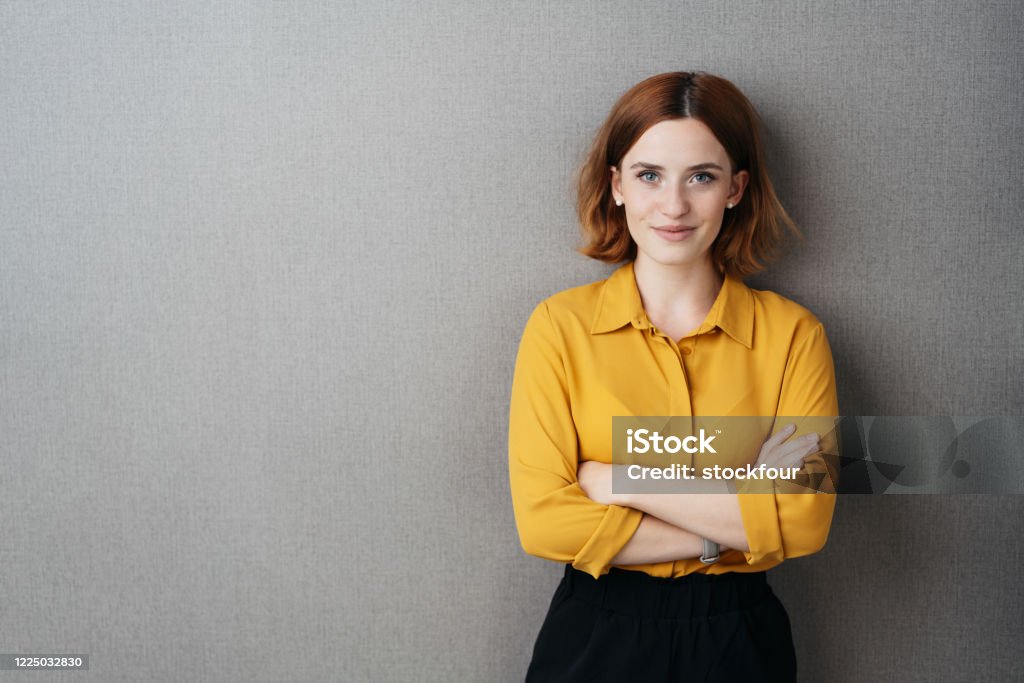 Freundliche selbstbewusste junge Frau über grau - Lizenzfrei Eine Frau allein Stock-Foto