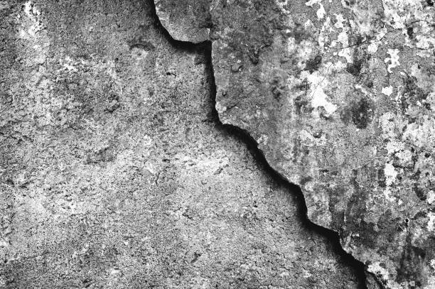 istock Concrete wall with a partially removed layer of surface with a beautiful curly border. Background. Black and white image. 1225033220