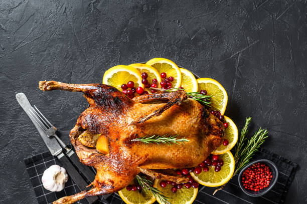 istock Baked goose stuffed with oranges and rosmarina. Festive table. Black background. Top view. Space for text 1225034401