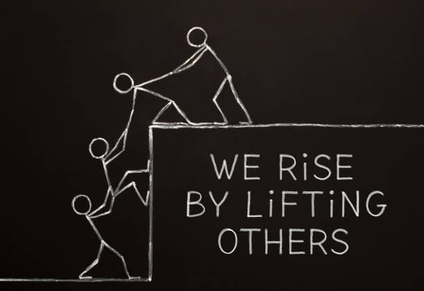 We Rise By Lifting Others Concept Quote We Rise By Lifting Others handdrawn on altruism, kindness, unselfishness, or teamwork concept drawn with chalk on blackboard. altruism photos stock pictures, royalty-free photos & images