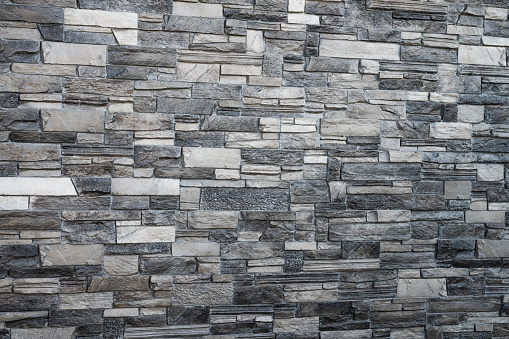 decorative gray wall laid out of tiles on a flat surface.