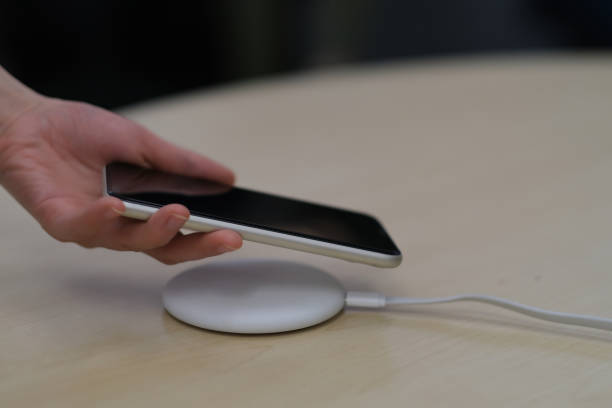 istock close up one hand putting smartphone on wireless charger. 1225037555