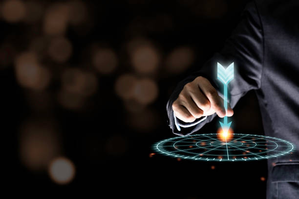istock Businessman hand holding and throwing virtual dart to target board on black background.Business and investment target concept. 1225040271