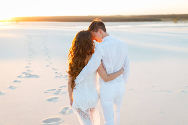 istock groom hugging bride in the desert at sunset 1225040488