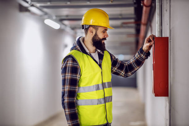 istock Young handsome bearded electrician standing in building in rebuilding process and checking out distribution box. 1225040661