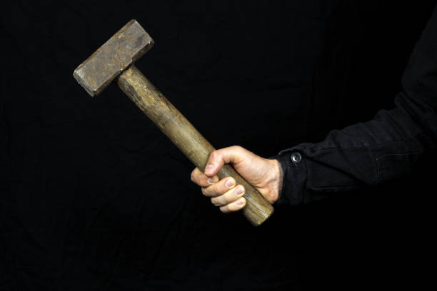 istock sledgehammer, hammer in the hand of a worker on a black background 1225041456