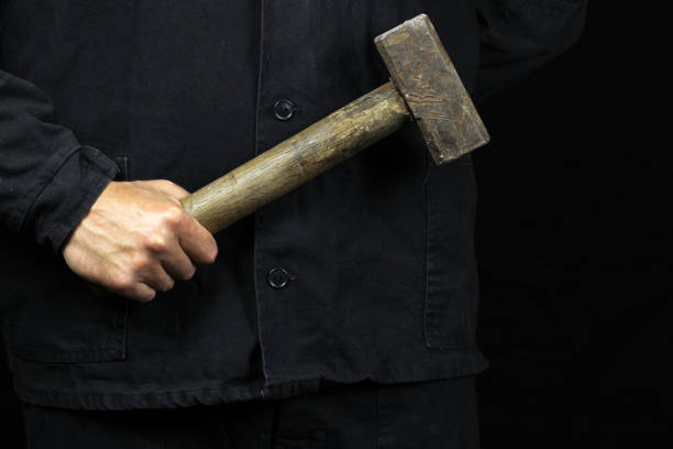 sledgehammer, hammer in the hand of a worker on a black background