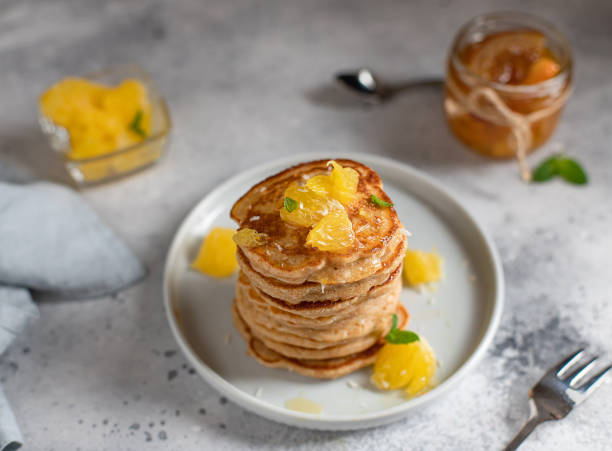 leckere pfannkuchen mit orange und marmelade serviert. grauer betonhintergrund - low back stock-fotos und bilder