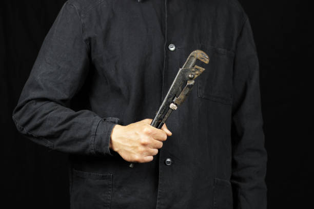 istock Mechanic hand hold pipe wrench on black background 1225041816