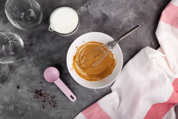 istock Cooking a popular Korean Dalgon coffee step by step. Step 5 soluble coffee, sugar and hot water whipped into lush foam on dark grey background. Flat Lay, top view 1225041831