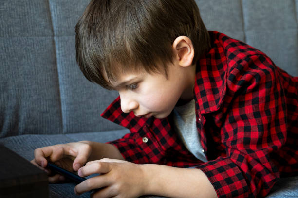 istock Focused boy enthusiastically plays in a smartphone. 1225041936