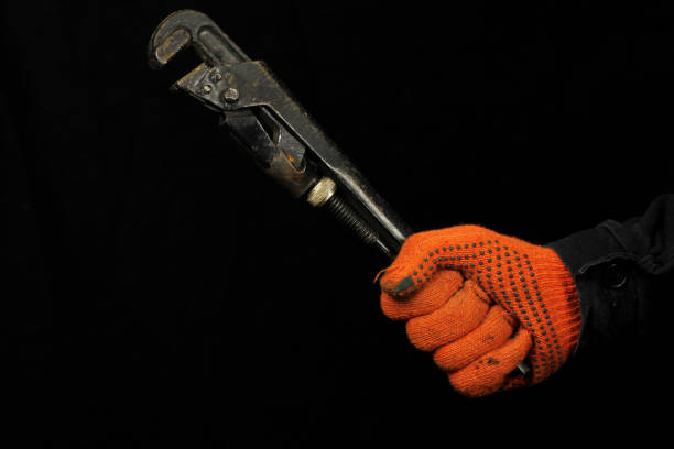 istock Mechanic hand hold pipe wrench on black background 1225041938