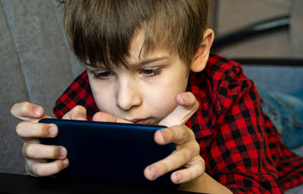 istock Focused boy enthusiastically plays in a smartphone. 1225041952