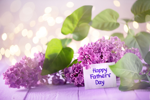 Father`s Day Greeting Card on a Lilac Flower Arrangement