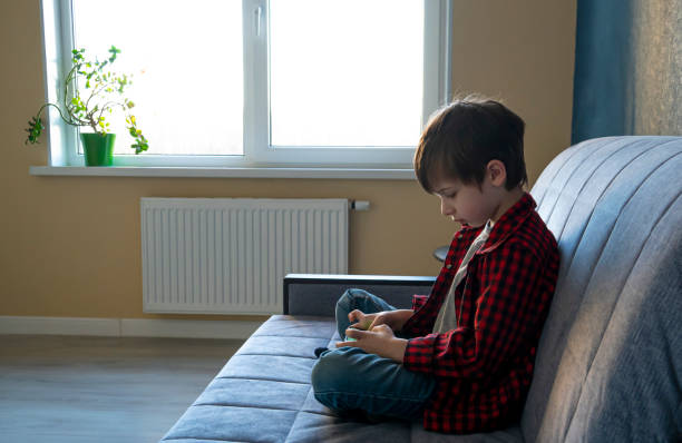 istock Focused boy enthusiastically plays in a smartphone. 1225041978