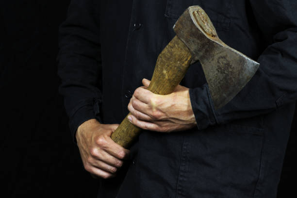 istock Axe in male hands in work clothes on a black background 1225042052