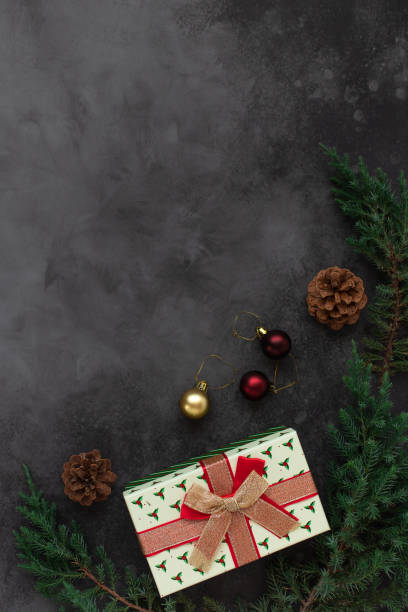 istock Christmas background with present box and decorations of tree branches and cones 1225042334