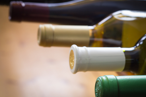 Wine bottles stacked on wooden racks shot with limited depth of field