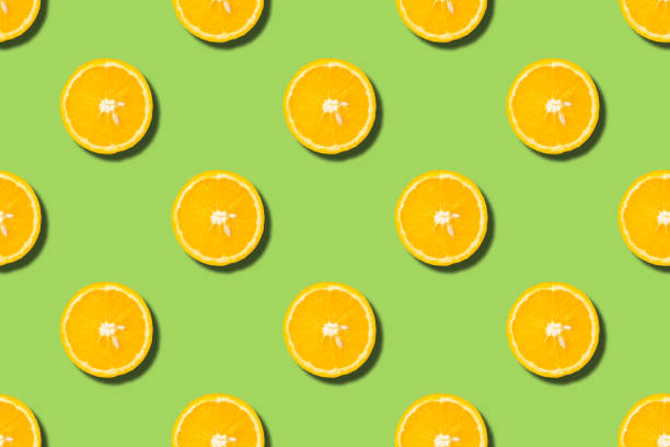 istock Colourful fruit seamless pattern of orange halves on green background. Top view 1225044562