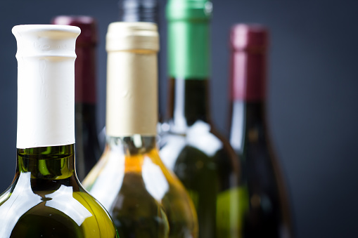Wine bottles in a row isolated on a gray background