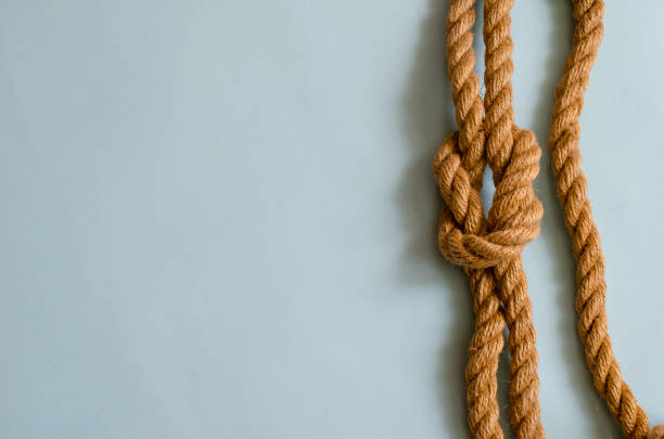 istock Hemp rope with a nautical knot on a light blue background. 1225045217